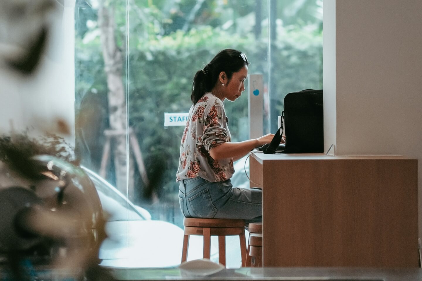 a woman sitting in front of the computer in the cafe working on a new design